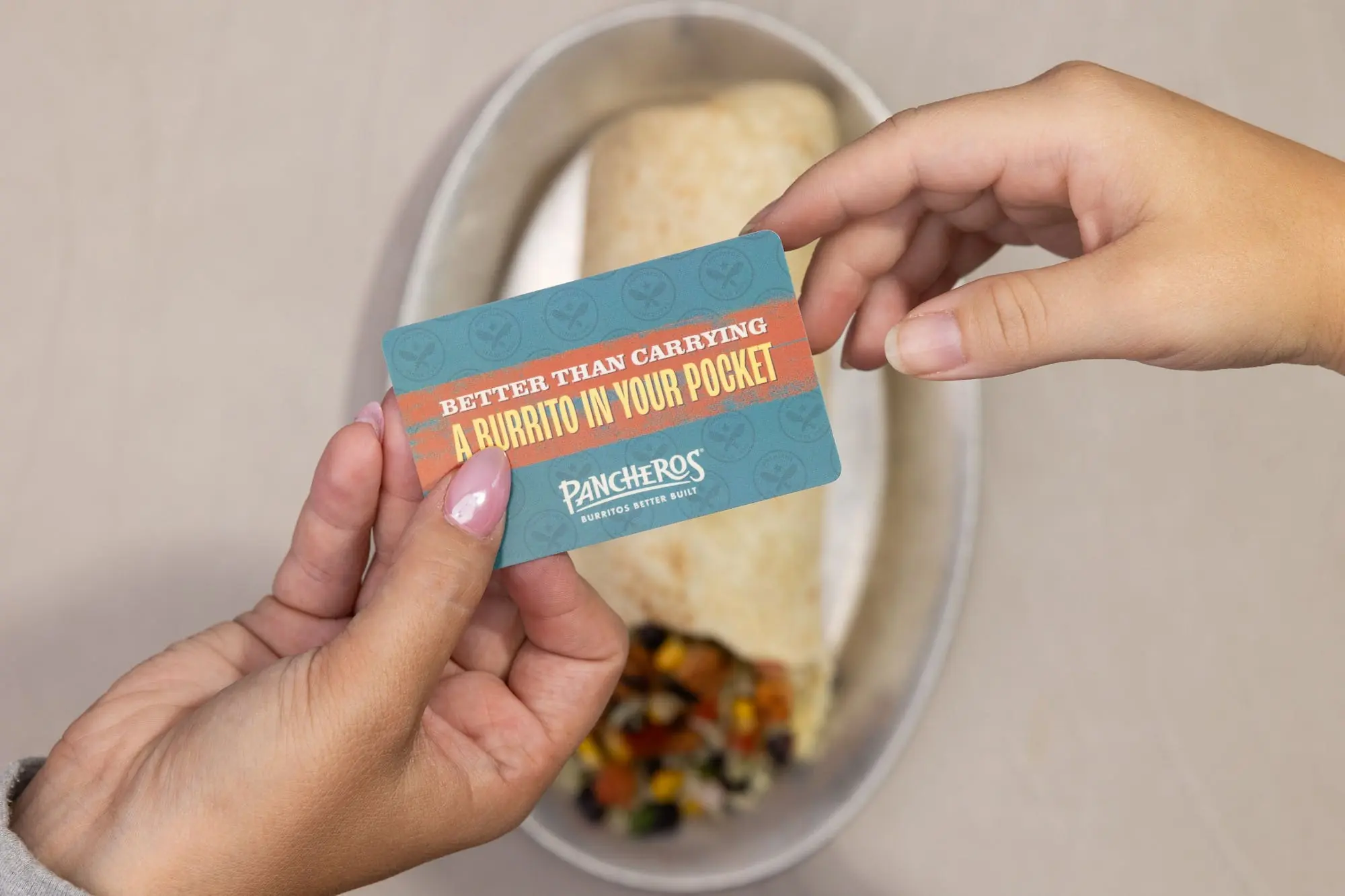 Handing off a Pancheros gift card with a burrito in the background